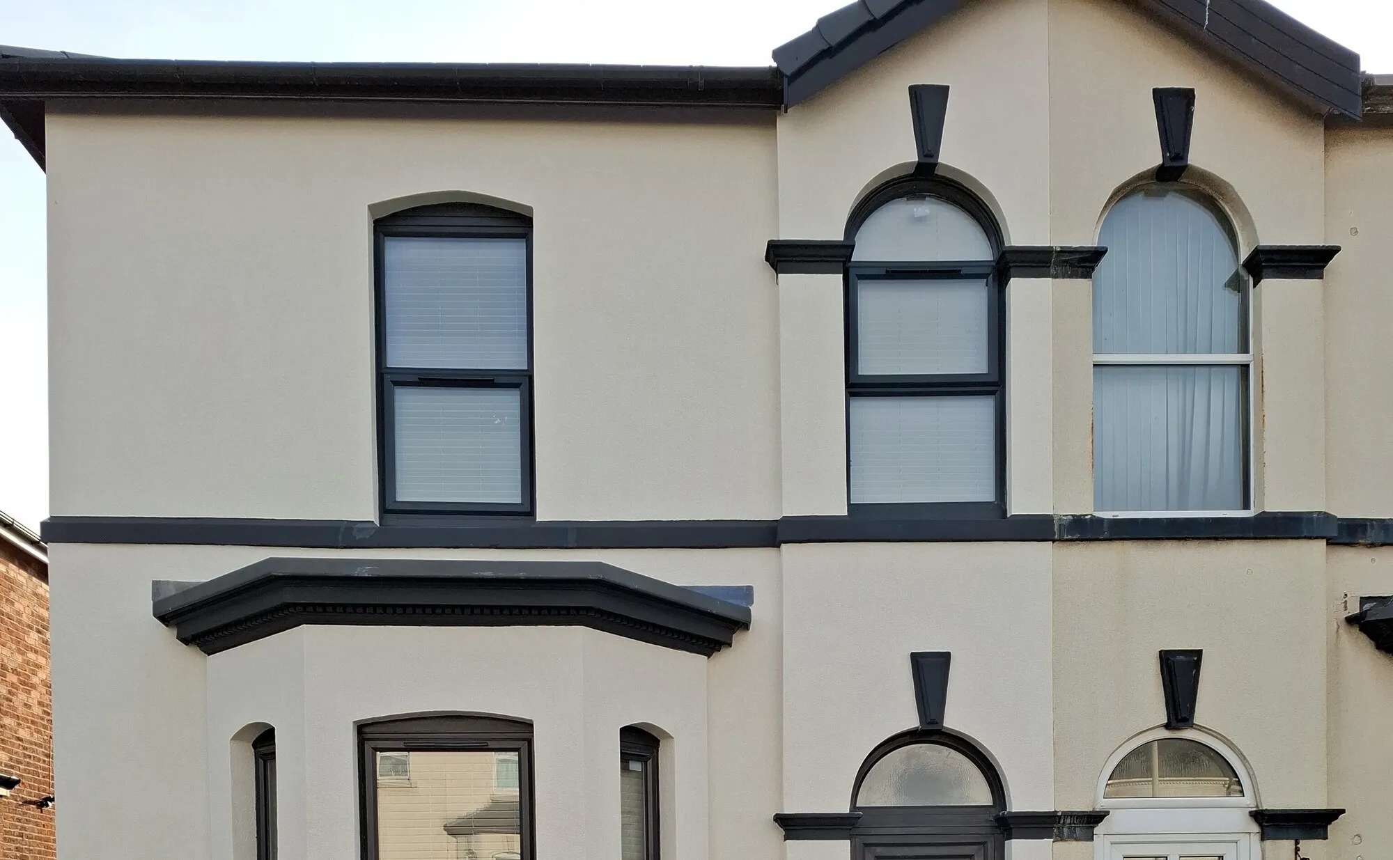 A rendered Victorian terrace finished by Pro Build, with black window surrounds and a panelled front door